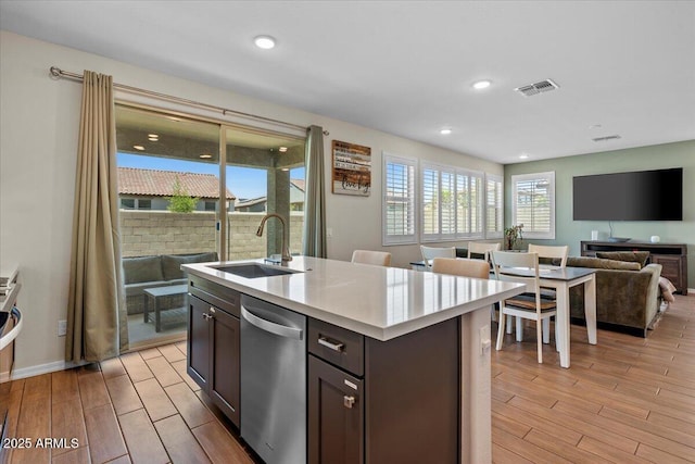 880 S 150th Dr, Goodyear, AZ 85338 - kitchen featuring dishwasher, light wood finished floors, dark brown cabinets, light countertops, and open floor plan