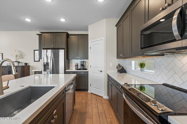 880 S 150th Dr, Goodyear, AZ 85338 - kitchen with appliances with stainless steel finishes, decorative backsplash, wood finished floors, light countertops, and recessed lighting