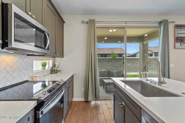 880 S 150th Dr, Goodyear, AZ 85338 - kitchen with appliances with stainless steel finishes, wood finished floors, decorative backsplash, light countertops, and plenty of natural light