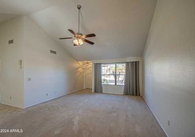 empty room with ceiling fan, light colored carpet, a textured ceiling, and high vaulted ceiling