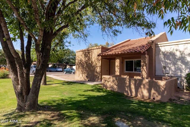 view of home's exterior featuring stucco siding, a lawn, and a tile roof