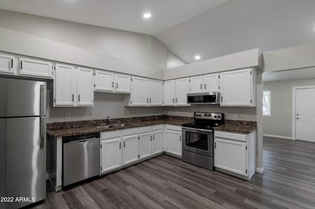 kitchen with white cabinetry, stainless steel appliances, lofted ceiling, and a sink