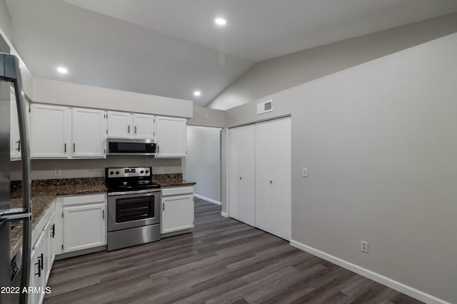 kitchen featuring dark wood finished floors, lofted ceiling, white cabinets, and appliances with stainless steel finishes