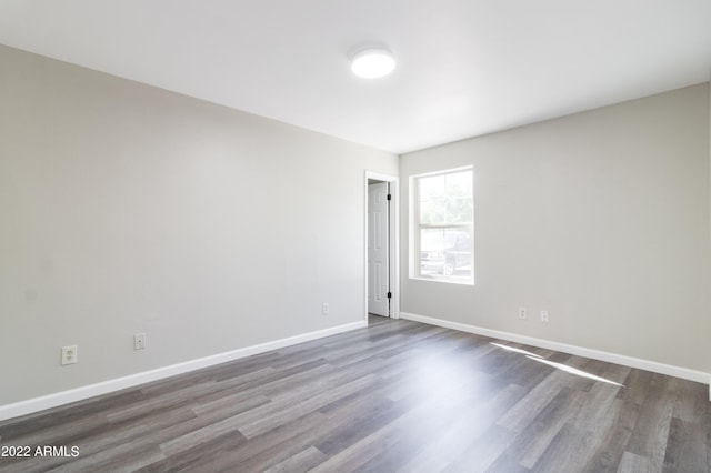 empty room with baseboards and dark wood finished floors
