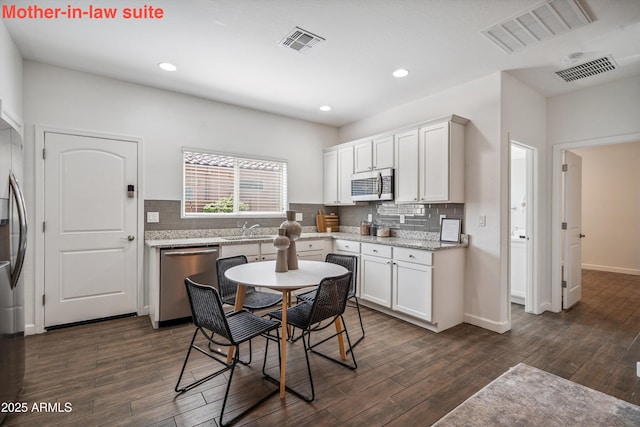 13529 W Remuda Dr, Peoria, AZ 85383 - kitchen with stainless steel appliances, tasteful backsplash, dark wood finished floors, white cabinetry, and recessed lighting