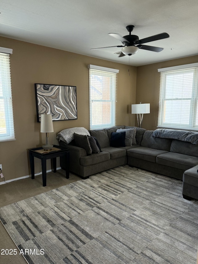 living room featuring light carpet, ceiling fan, and a healthy amount of sunlight