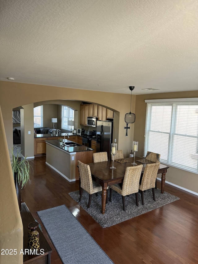 dining room featuring a textured ceiling, dark hardwood / wood-style floors, and sink