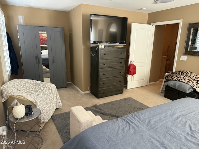 bedroom featuring light carpet and a closet