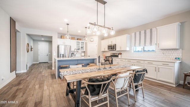 dining area featuring recessed lighting, light wood-style flooring, and baseboards