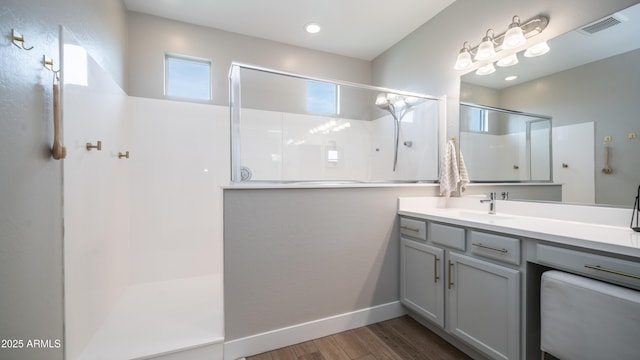 full bath with wood finished floors, visible vents, vanity, and a walk in shower