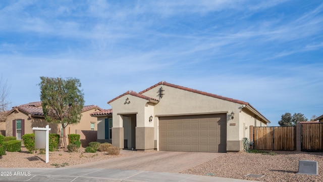 mediterranean / spanish house featuring a garage, fence, decorative driveway, and stucco siding