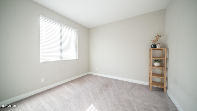 unfurnished room with carpet flooring and baseboards