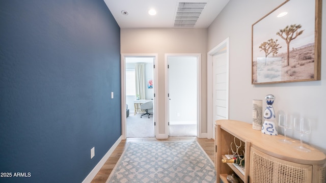 interior space with baseboards, visible vents, and wood finished floors