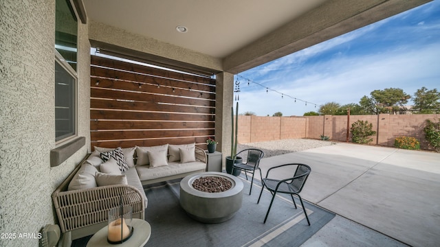 view of patio with an outdoor living space with a fire pit and a fenced backyard