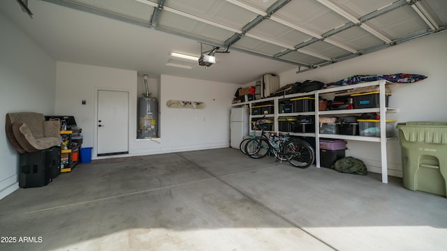 garage featuring gas water heater, freestanding refrigerator, and a garage door opener