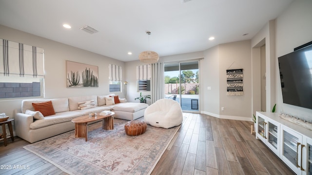 living room featuring dark wood-type flooring, recessed lighting, visible vents, and baseboards