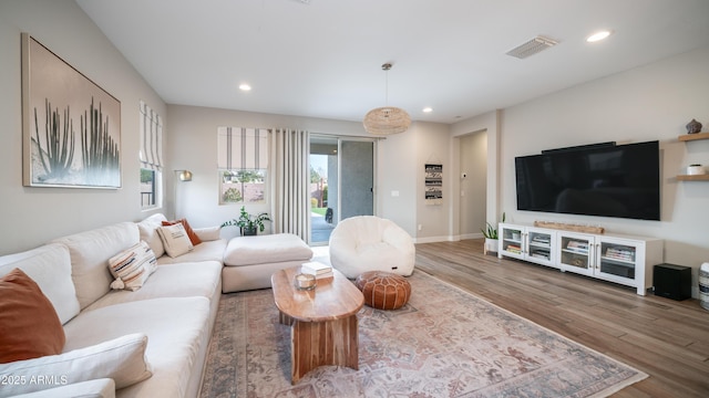 living area featuring baseboards, wood finished floors, visible vents, and recessed lighting