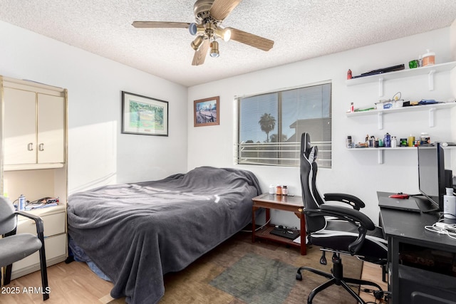 bedroom with ceiling fan, dark hardwood / wood-style floors, and a textured ceiling