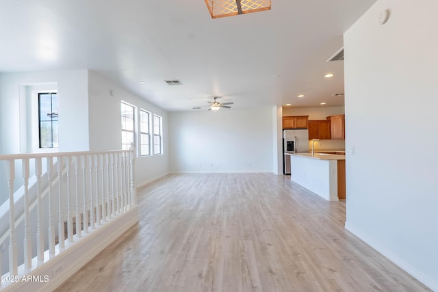 unfurnished living room featuring a ceiling fan, visible vents, baseboards, light wood finished floors, and recessed lighting