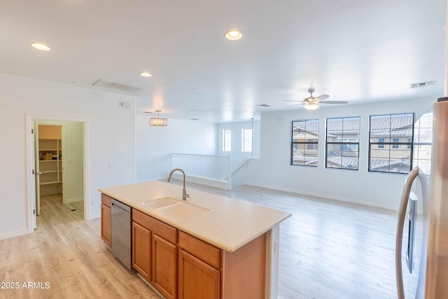 kitchen featuring visible vents, a sink, light wood-style flooring, freestanding refrigerator, and stainless steel dishwasher