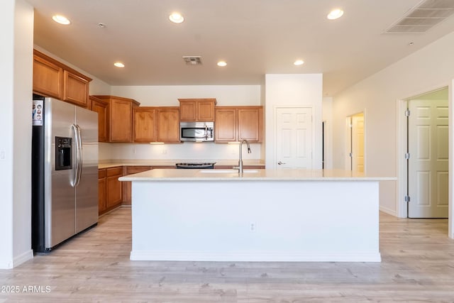 kitchen featuring light countertops, a center island with sink, visible vents, and stainless steel appliances