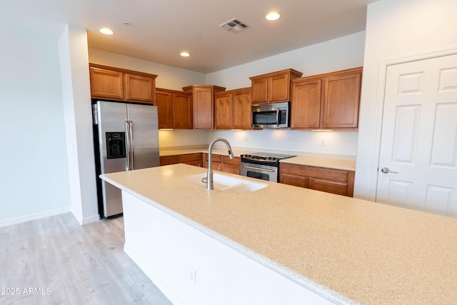 kitchen with visible vents, recessed lighting, a sink, stainless steel appliances, and brown cabinets