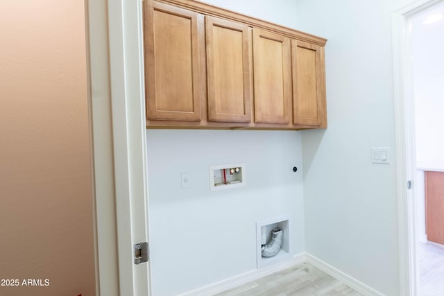 washroom with baseboards, hookup for an electric dryer, cabinet space, washer hookup, and light wood-style floors