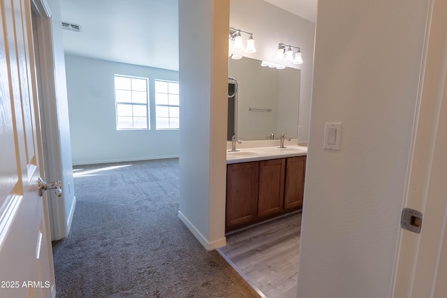 bathroom featuring double vanity, baseboards, visible vents, and a sink