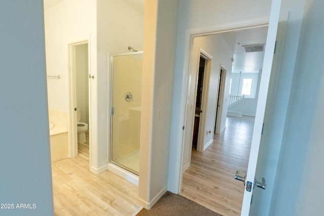 bathroom with visible vents, a shower stall, baseboards, toilet, and wood finished floors