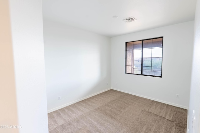 empty room with visible vents, baseboards, and carpet