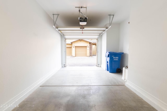 garage featuring a garage door opener and baseboards