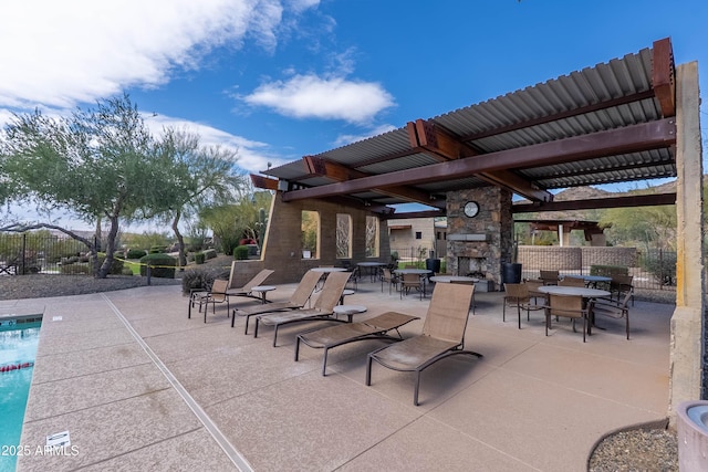 view of patio with a gazebo, fence, and an outdoor stone fireplace