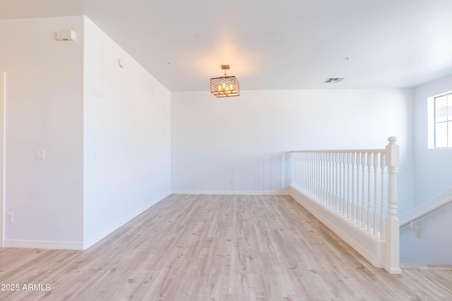 spare room featuring visible vents, baseboards, and light wood-type flooring