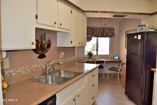 kitchen featuring white cabinetry, black fridge, sink, and light tile patterned floors