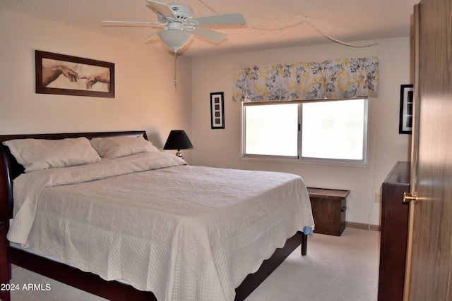 bedroom with a textured ceiling, carpet floors, and ceiling fan