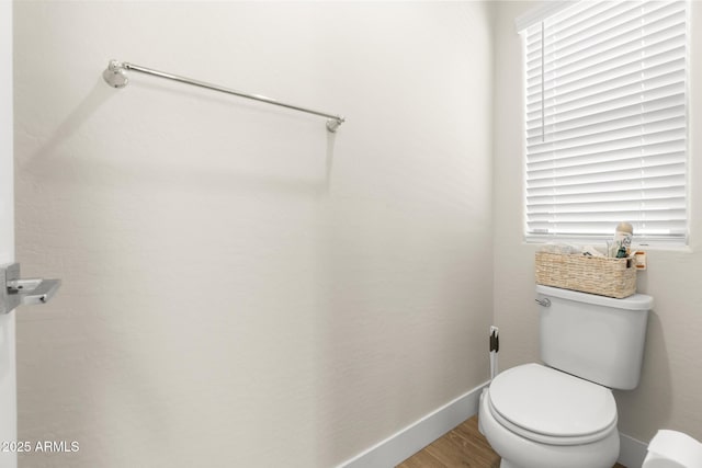 bathroom featuring wood finished floors, toilet, and baseboards