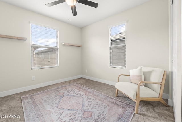 living area featuring carpet floors, a ceiling fan, and healthy amount of natural light