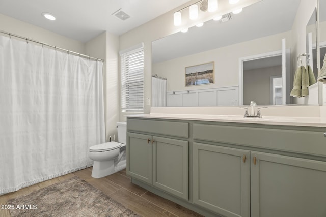 full bathroom with toilet, vanity, and wood finished floors