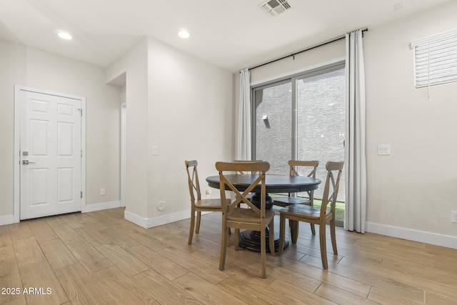 dining space with light wood finished floors, baseboards, healthy amount of natural light, and recessed lighting