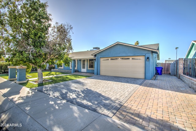 ranch-style home featuring a front yard and a garage