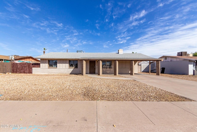 ranch-style home with a carport and central AC unit