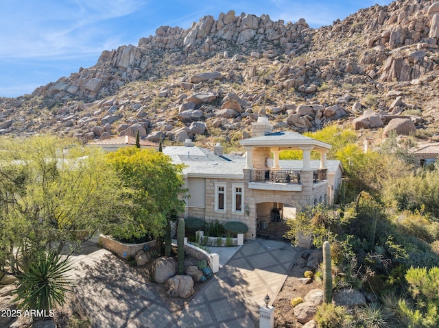 back of property featuring a gazebo, a balcony, and a mountain view