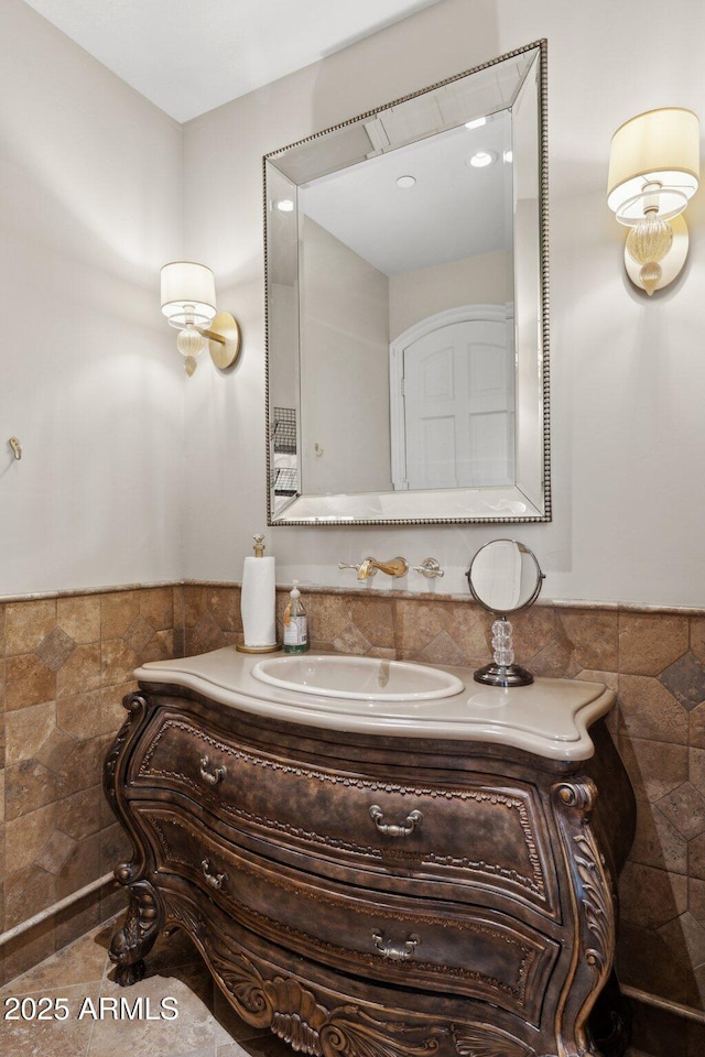 bathroom with vanity and tile walls