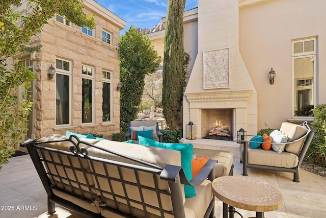 view of patio with an outdoor living space with a fireplace