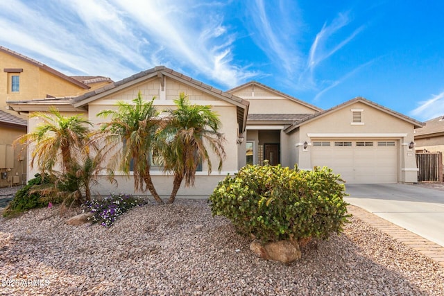 view of front of house with a garage, concrete driveway, a tiled roof, and stucco siding