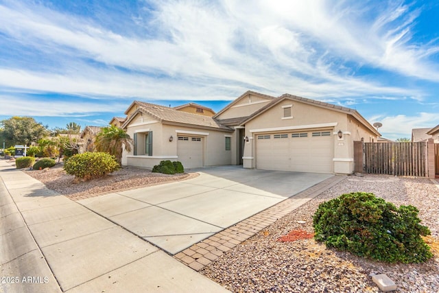 view of front facade with concrete driveway, stucco siding, fence, and an attached garage