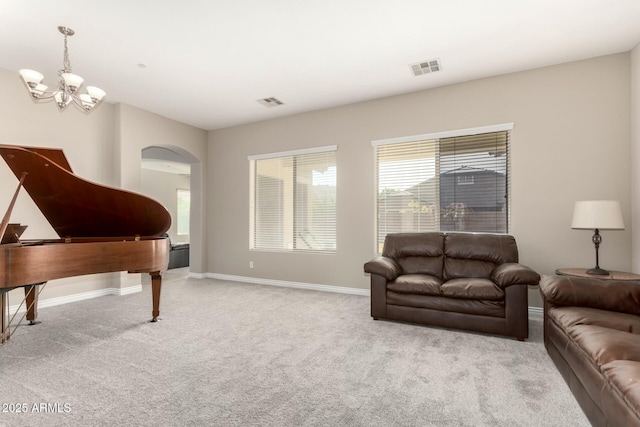 living area featuring baseboards, arched walkways, visible vents, and light colored carpet