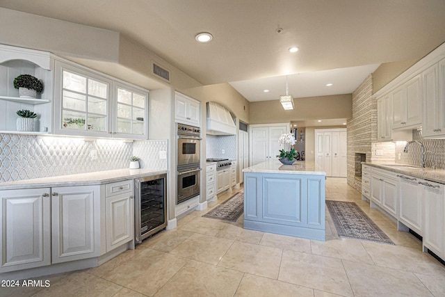 kitchen with white cabinetry, wine cooler, pendant lighting, decorative backsplash, and a kitchen island