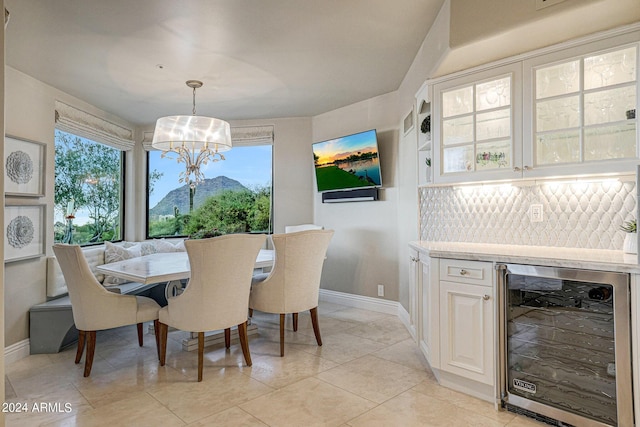 dining area featuring wine cooler, a notable chandelier, and light tile patterned flooring