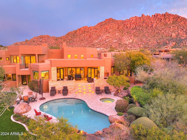 view of pool featuring a mountain view, an in ground hot tub, and a patio